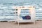 Canopy with white curtains on sandy beach by sea