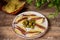 Cantabrian anchovies presented on chips on a plate with olives, a typical Spanish tapa