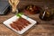 Cantabrian anchovies presented on a plate next to an oil can, olives and wooden toothpicks, rustic wood background