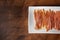 Cantabrian anchovies on a white plate with olive oil, rustic brown wooden background, copy space