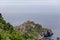 Cantabrian Sea ceaselessly erodes rocky coast creating tunnels, arches, and caves on Gaztelugatxe island with 9th-century church