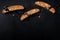 Cantucci. Traditional Italian almond cookies, shot from above on a black background with chocolate