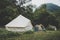 canvas bell tents outdoors at forest. Glamping at the forest. Tourist camp with lots of tents in the woods