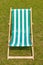 Canvas deckchair on a grassy lawn in the summer.