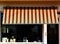 Canvas fabric awning sunshade in brown and orange over display window