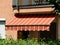 Canvas fabric awning sunshade in yellow and orange over a balcony. sun and rain protection