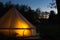 Canvas glamping tent glows at night