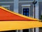 canvas patio awning. colorful sun shade sail UV protection fabric suspended from exterior walls.