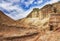 A canyon among the ancient desert steppe fields, geological deposits of different times, clay, erosion, stones.