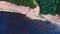 A canyon with mineral rocks, a coniferous forest and a river with dark water.