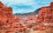 Canyon, mountain erosion, plateau, cloudy sky and mountains on the horizon. Red rocks and layers