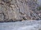 Canyon of mountain river in winter scenery with distant rock climbers