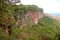 Canyon wall covered by green vegetation in sunny day