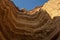 Canyon wall viewed from below in arc format with detail of water erosion marks. Namibe. Angola. Africa