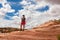 Canyonlands - Woman standing on layered rock formation near Mesa Arch, Moab, Canyonlands National Park, Utah, USA