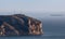 Cape Antonio in Spain from a distance with a container ship at sea.