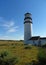 Cape Cod HIghland lighthouse with summer blue sky, green marsh grass