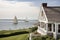 cape cod house with open view of the ocean, and sailboats on the horizon