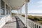 cape cod house with wrap-around porch, overlooking the beach