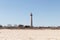 This is Cape May point lighthouse seen from the beach. The tall white structure with red metal serves as a beacon of safety.