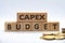 Capex budget text engraved on wooden blocks on white background cover. Business and budgeting concept