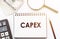 CAPEX text written on a notebook with office background