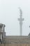 Capital city landmark Sigismund\'s Column silhouette in fog view from stone stairs in Polish Warsaw