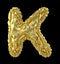 Capital latin letter K made of crumpled gold foil isolated on black background