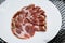 Capocollo or coppa, Italian ham slices on white plate