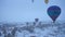 CAPPADOCIA, TURKEY - APRIL 10, 2021: Hot-air balloons in Snowy Cappadocia in Winter Morning. Turkey. Aerial View