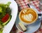 Cappuccino with cake on a rustic tablecloth