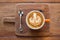 Cappuccino coffee cup served on wooden board top view. Shallow D