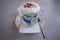 Cappuccino coffee in porcelain cup with instructions of knot bin