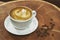 Cappuccino coffee in a white cup on a wooden table with a modern