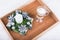 A cappuccino drink and Christmas decoration with candle, fir branch and silver balls on white furry carpet