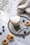 Cappuccino or latte with milk foam in a cup with homemade berry cookies and blueberries on a light background with gypsophila