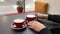 Cappuccino or latte in red cups for couple or friends. Coffee morning in the cafe. Person sliding a cup of coffee towards him