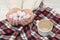 Cappuccino and meringue in female hands, checkered plaid. Fashionable concept