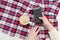 Cappuccino, smartphone in female hands, checkered plaid. Fashionable concept