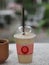 Cappuccino smoothie in a clear plastic glass on marble table, coffee cold drink