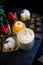 Cappuccino, sweets mousse cakes and chocolate pieces. Spruce branches decorated for Christmas are visible in the background