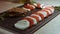 Caprese - italian national dish. Sliced tomatoes and mozarella arranged in shape of Christmas candy cane. Seasoning with