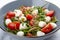 Caprese salad, cherry tomatoes, mozzarella, arugula and pesto sauce. Isolated image