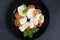 Caprese salad on a large black plate