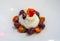 A caprese salad with mozzarella cheese made with donkey\\\'s milk, colored cherry tomatoes and basil, all on a white plate