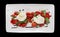 Caprese salad shot from above, isolated on black
