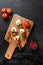 Caprese salad skewer with tomato on sticks  Italian traditional caprese salad ingredients. Mediterranean food. over black stone