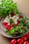 Caprese salad with tomato, mini mozzarella and basil on a brown background