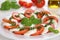 Caprese salad with tomatoes and mozzarella cheese on plate