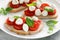 Caprese toasts with mini mozzarella cheese, cherry tomato and basil